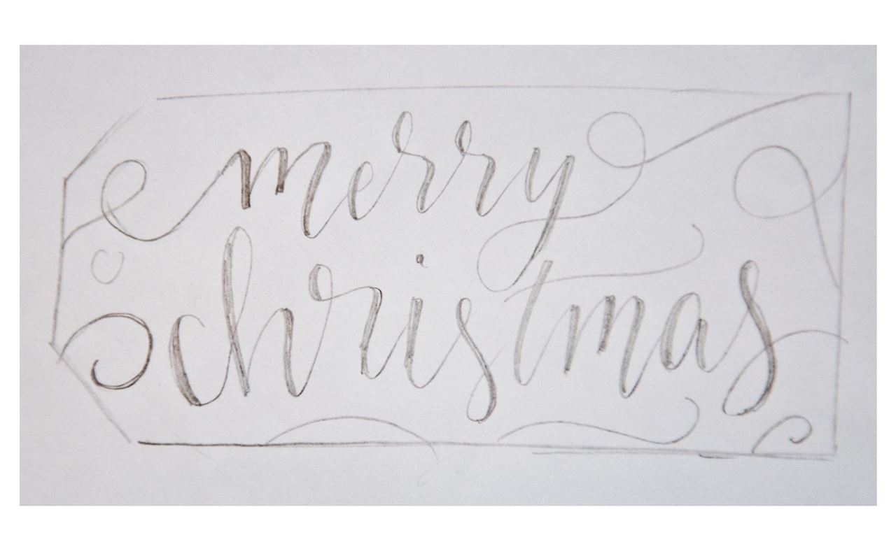Handlettering of a "merry christmas"  gift tag with a graphite pencil.
