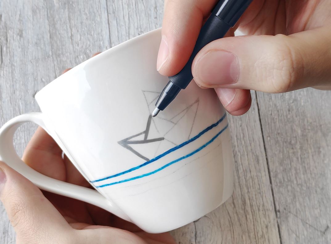 A paper boat getting painted on a cup.